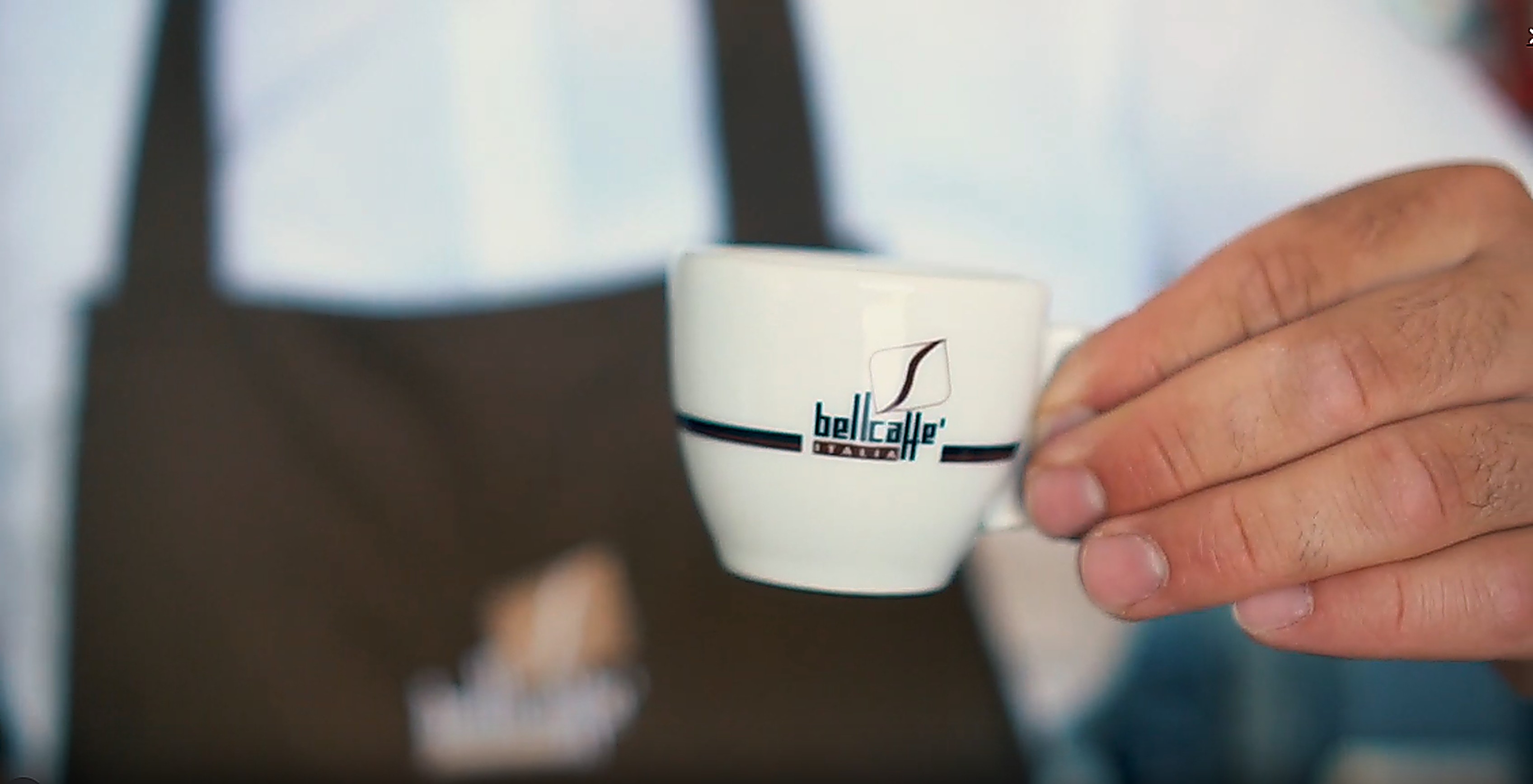 Barista drží šálek Bellcaffe